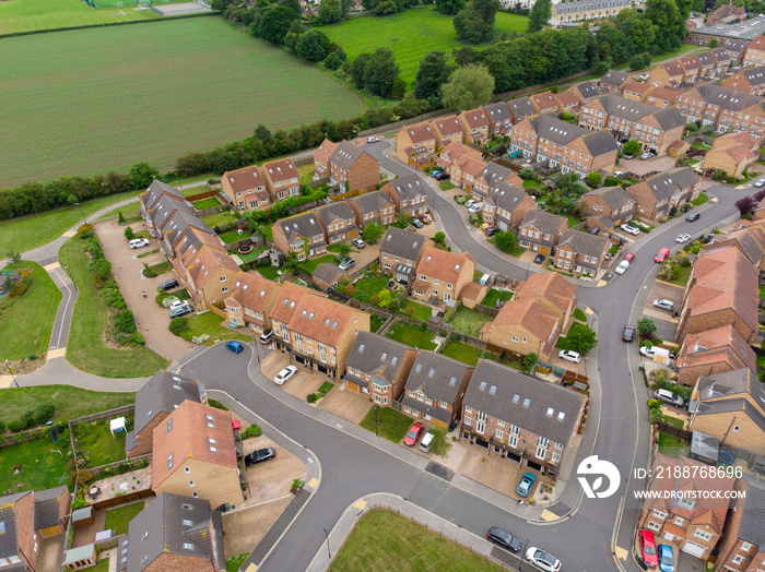 Aerial photo of a typical UK British hosing estate in the North Yorkshire town of York, taken on a sunny part cloudy day using a drone, showing the housing estate and farmers fields.