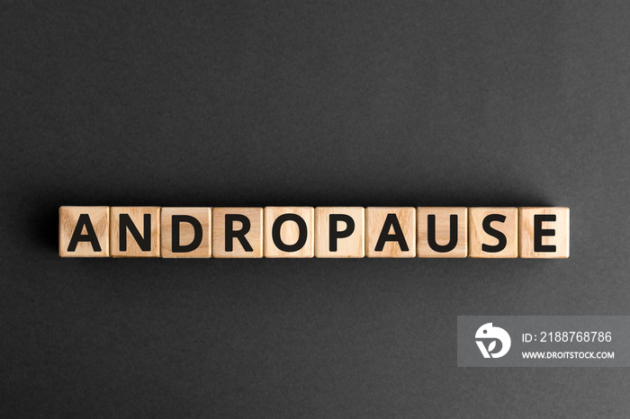 Andropause - word from wooden blocks with letters, symptoms middle-aged men testosterone level andropause concept, random letters around, top view gray background