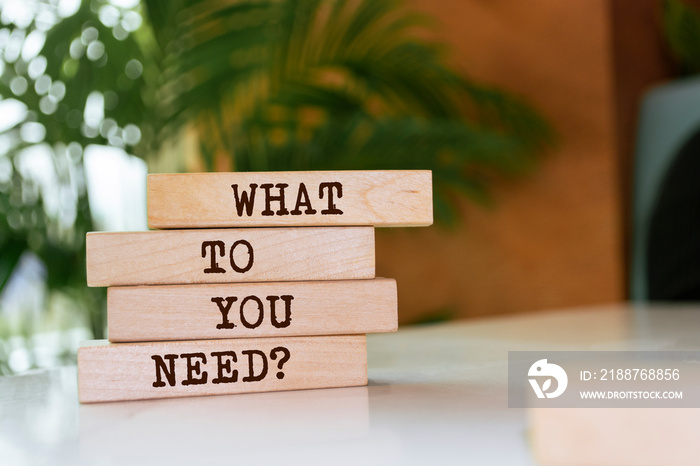 Wooden blocks with words ’What Do You Need?’.