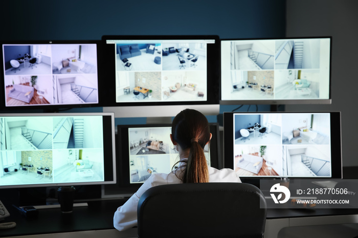 Security guard monitoring modern CCTV cameras in surveillance room