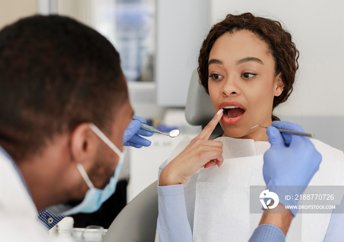 Female patient in dentist chair showing her teeth