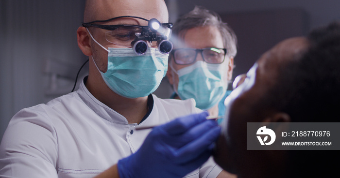 Focused dentists treating teeth of patient