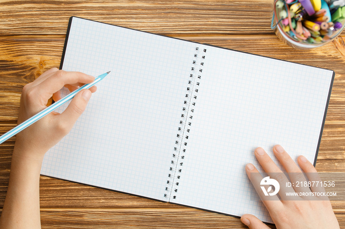 hands hold notebook with pencil and blank sheets