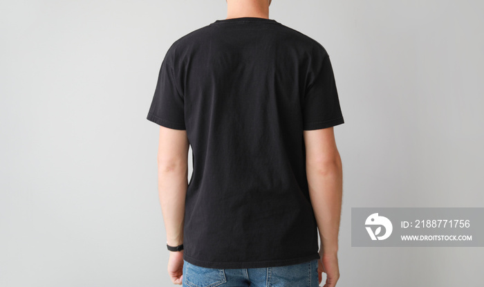 Man in stylish t-shirt on light background, back view