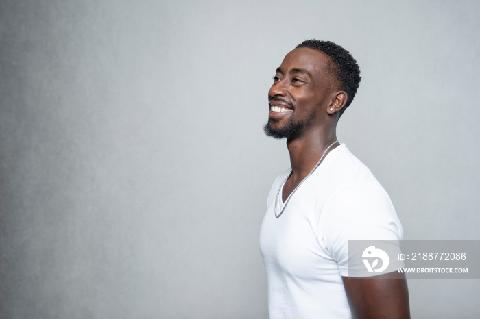 Portrait of smiling man wearing white t-shirt and necklace