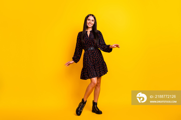 Photo of impressed sweet young lady dressed black clothes dancing isolated yellow color background