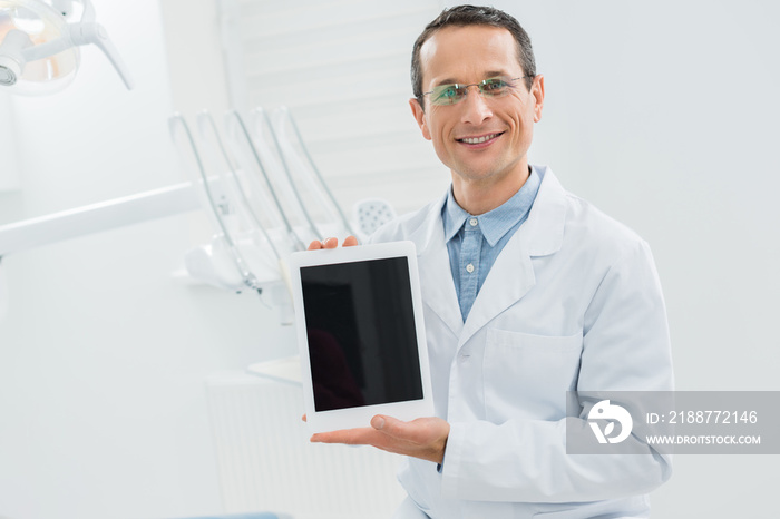 Dentist showing empty tablet screen modern dental clinic