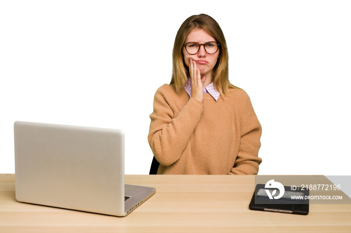 Young caucasian woman in a workplace working with a laptop isolated having a strong teeth pain, molar ache.