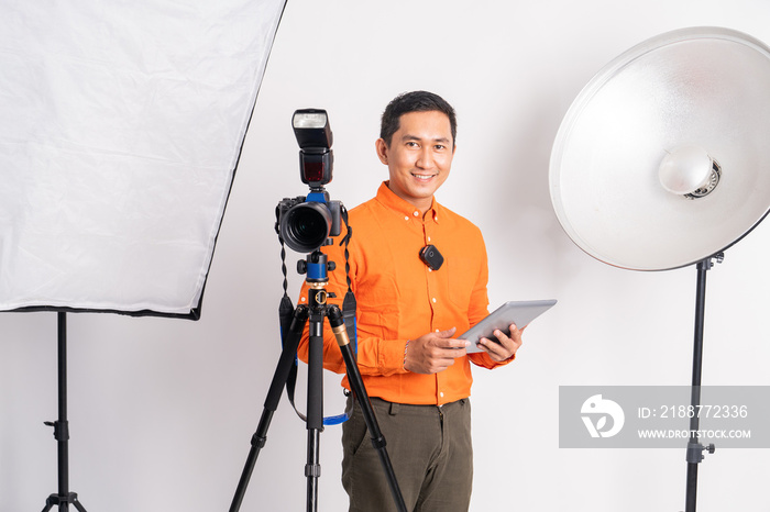 vlogger standing behind camera and holding pad with lighting equipment on isolated background