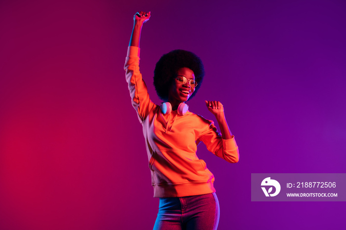 Portrait of positive pretty dark skin lady enjoy dancing toothy smile isolated on vivid color background