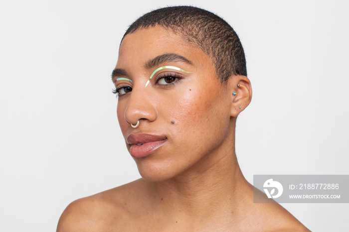 Studio portrait of woman with golden foil make-up