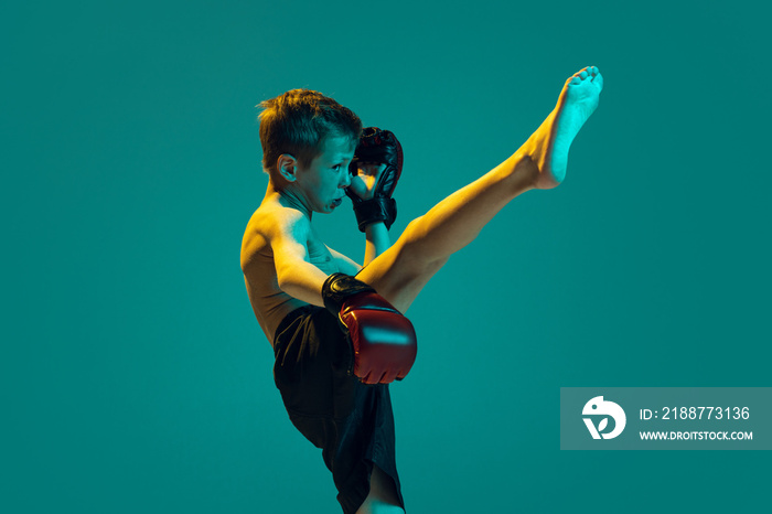 Young sportsmen, beginner fighter of mma sport in action isolated on cyan color background. Sport, education, action, motion concept.