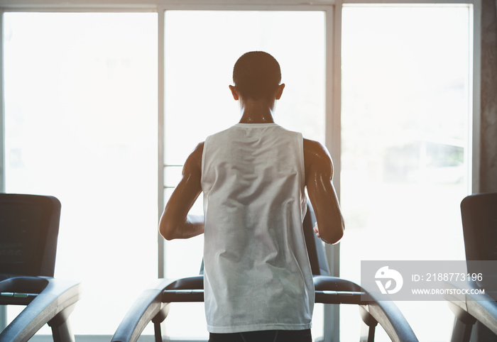 Back side of asian athlete sportsman runner tan skin running on treadmill in fitness club. Cardio workout. Healthy lifestyle, guy training in gym. Sport running concept.