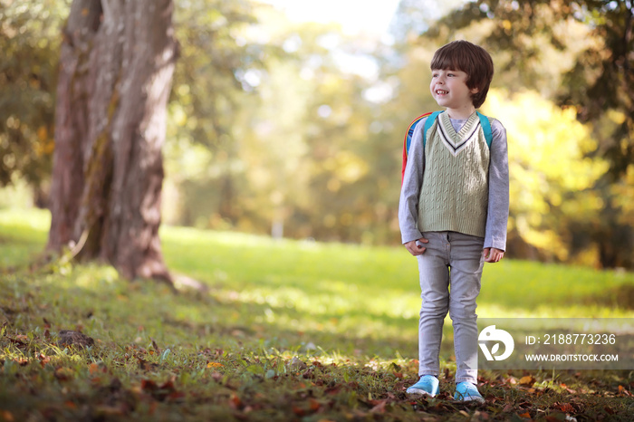 Children with briefcases for a walk in the park. School break. The beginning of the children’s studies.