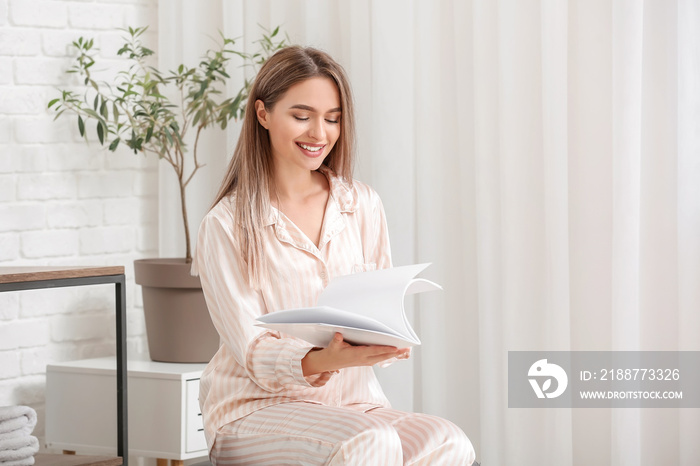 Beautiful woman reading blank magazine in bathroom