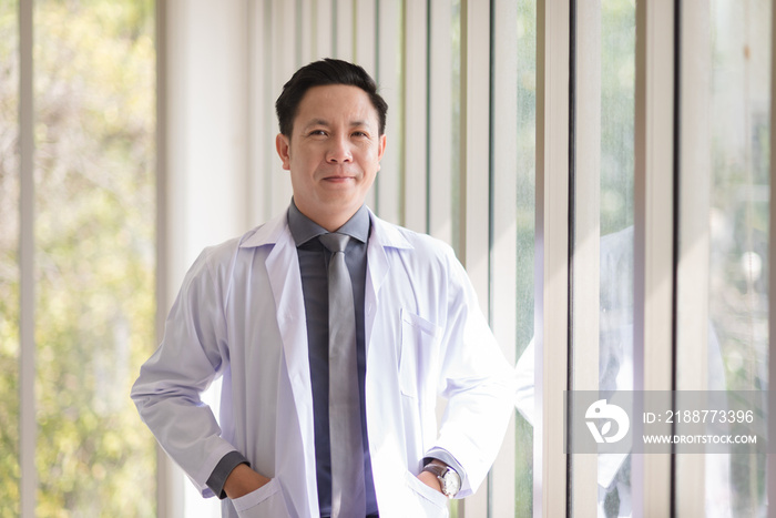 Asian doctor man portrait in professional uniform standing with smile and confidence.