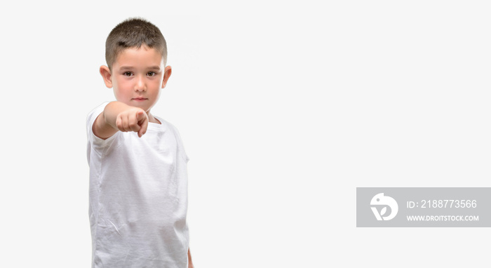 Dark haired little child pointing with finger to the camera and to you, hand sign, positive and confident gesture from the front