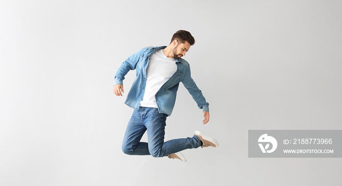 Jumping young man on light background