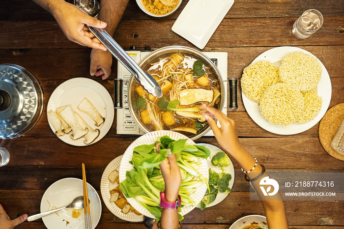 Family dinner eating hotpot together with the parents and kids in the evening