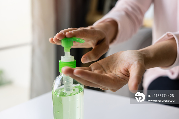 Young woman using alcohol gel sanitizer pump to avoid infections corona virus and bacteria