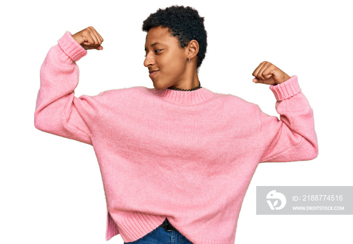 Young african american woman wearing casual clothes showing arms muscles smiling proud. fitness concept.