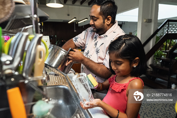 Children helping their parents wash up after dinner