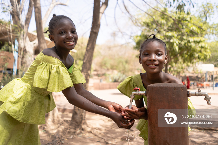 Clean hands for healthier life,african beautiful girls at the water point of their village.