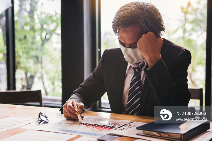 Bad investment or economic crisis from virus concept. Senior businessman with the mask is disappointed and seriously by badbusiness results report from virus crisis attack.