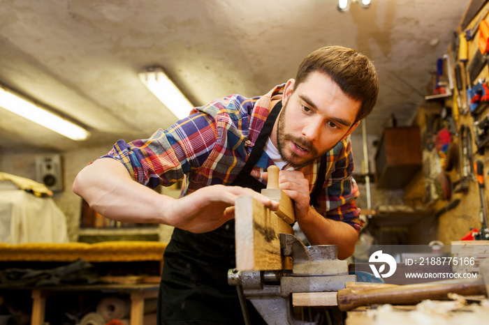 carpenter working with plane and wood at workshop