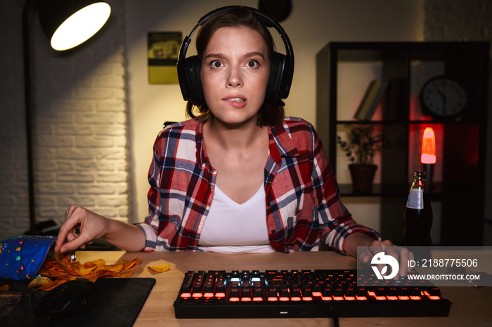 Excited girl wearing headset playing online games