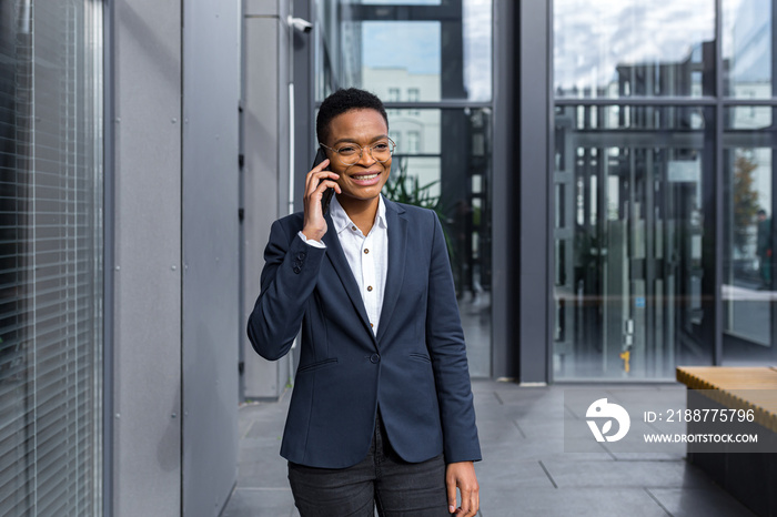 Successful and happy business woman having fun talking on the phone near the office, african american woman smiling talking