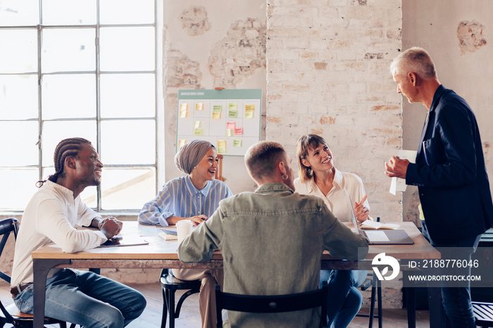 young business professional team sitting in a boardroom meeting at work with ceo in modern office - experienced business man working with creative professionals