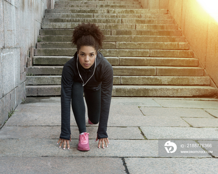 Modern brunette woman in sportswear preparing to workout outdoors