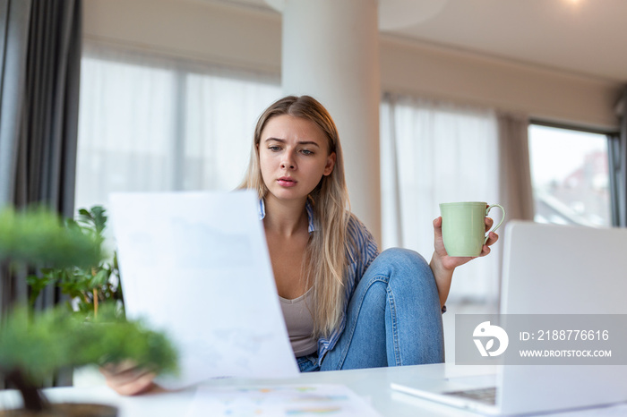 Serious frowning woman sit at workplace desk looks at laptop screen read e-mail feels concerned. Bored unmotivated tired employee, problems difficulties with app