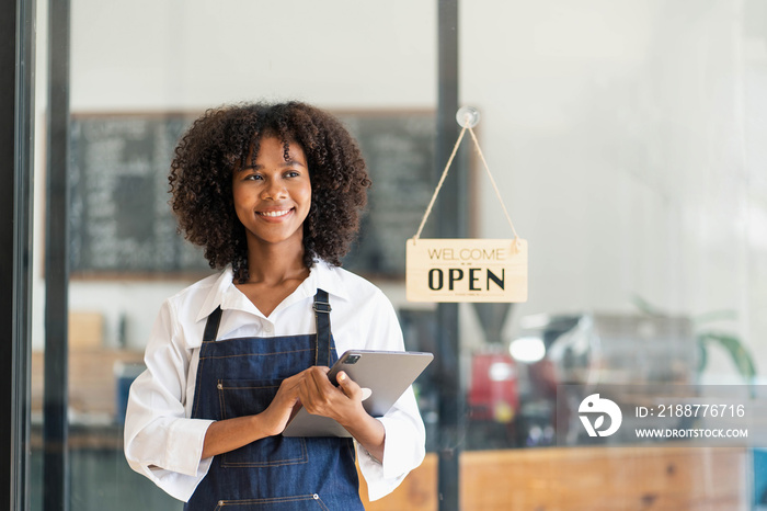 Startup successful small business owner sme beauty girl stand with tablet smartphone in coffee shop restaurant. Portrait of asian tan woman barista cafe owner SME entrepreneur seller business concept