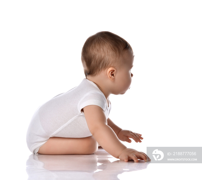 Portrait of sweet cute baby boy toddler in white body crawling on floor, side view