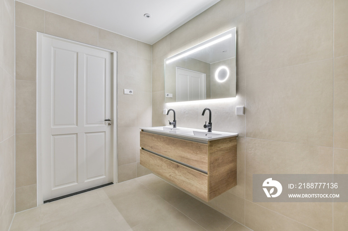 Interior of narrow restroom with sink and wall hung toilet with white walls and checkered floor