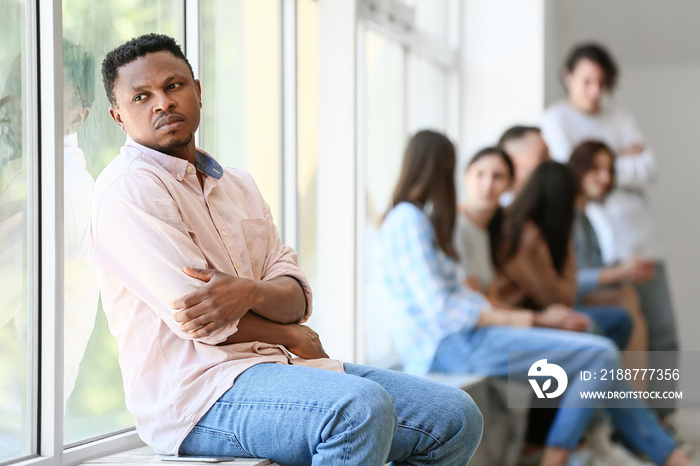 Lonely African-American man near window in hall. Stop racism