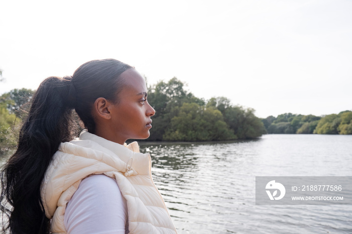 Portrait of young woman standing on lakeshore