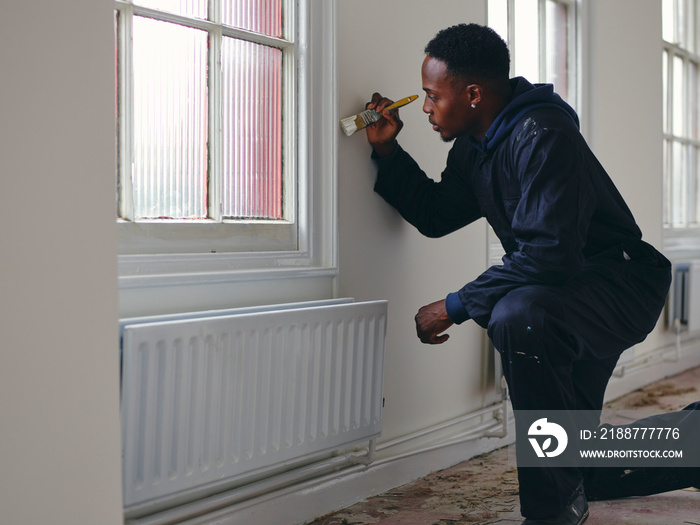 Man painting house walls white