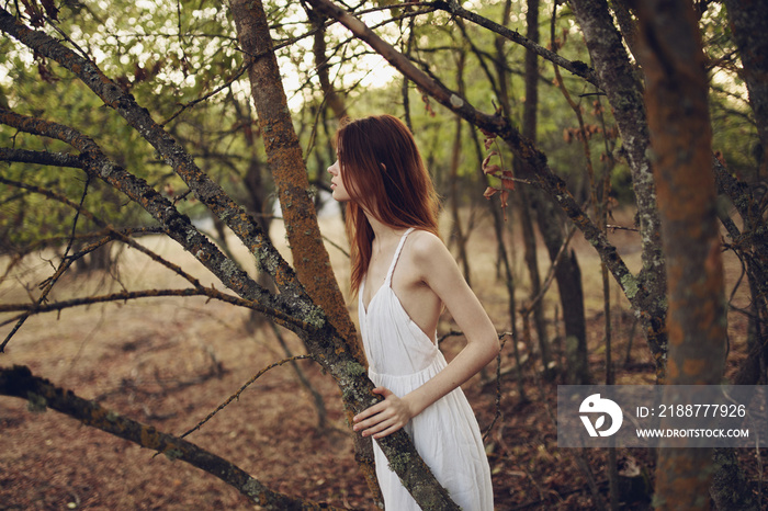 romantic woman in nature near trees in the forest