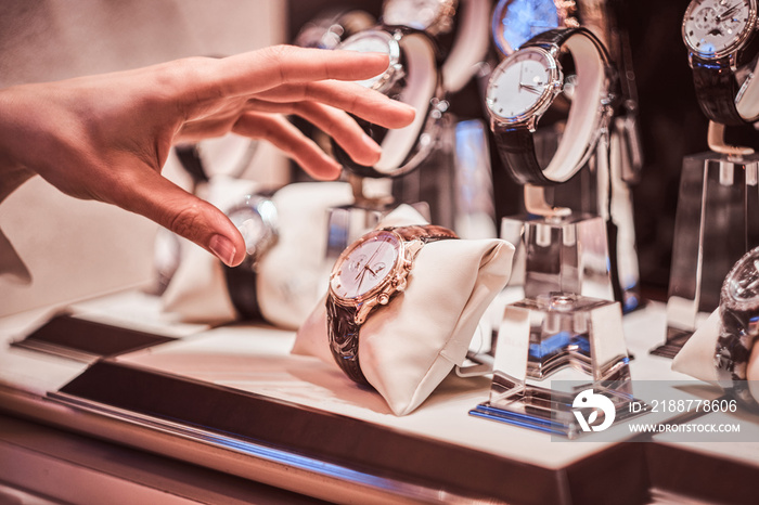 Close-up of the seller’s hand shows the exclusive men’s watch from the new collection in the luxury jewelry store