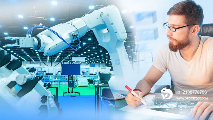 Testing an industrial robot. The engineer monitors the operation of the programmable robot and records the results. Production automation. Robotics. Use of robots in production.