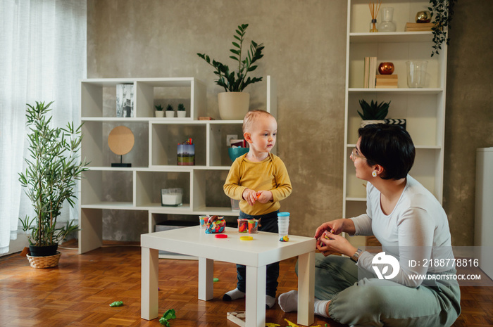 Mother and son playing with clay at home and creating art