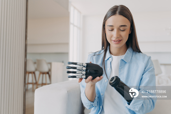 Disabled young woman is assembling bionic arm with hand. Prosthesis is connecting in wrist joint.