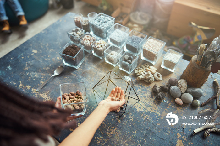 Experienced floral designer filling a polyhedron terrarium container