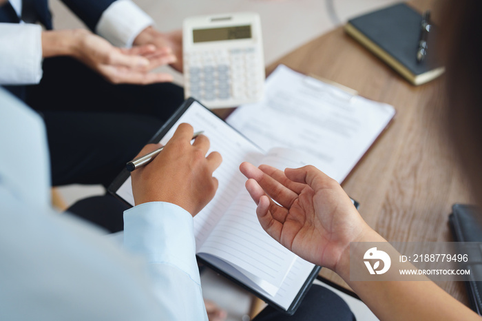 bank employee uses a calculator to calculate loan rates for customers