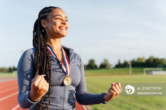 Portrait of female athlete celebrating with medal