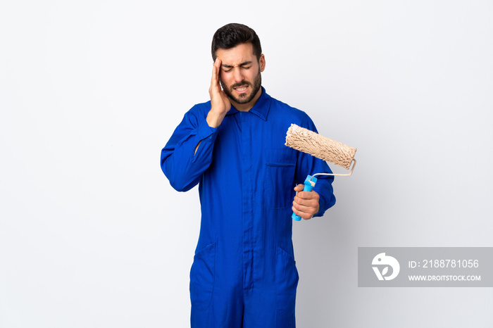 Painter man holding a paint roller isolated on white background with headache