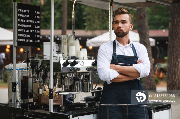 Handsome barista man during work in his street coffee shop